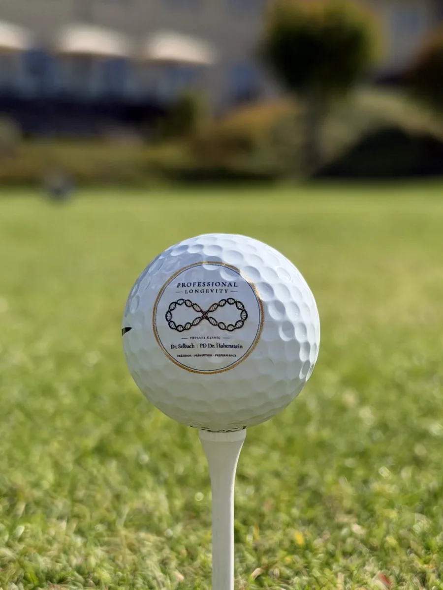 Golfball mit dem Signet von Professional Longevity auf dem Abschlag des Spa & GolfResort Weimarer Land